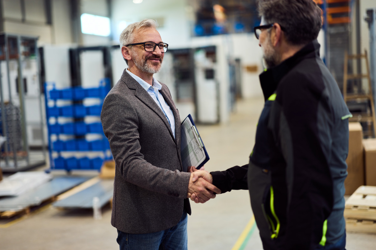 mechanical service business owner shaking hands with BCTS acquisitions team